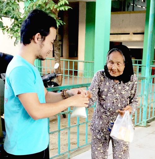 Thành viên Câu lạc bộ Tuổi trẻ Duy Xuyên trao sữa và bánh giúp người già neo đơn.
