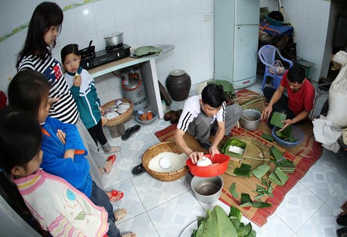 Những đứa trẻ háo hức xem gói bánh chưng.