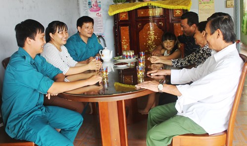 Đại diện chính quyền địa phương đến thăm gia đình, động viên Lạc Minh Quân (ngoài cùng, bên trái)trước ngày nhập ngũ.