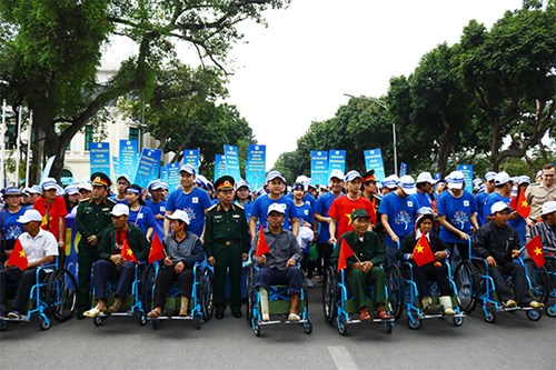 Các nạn nhân bom, mìn, vật nổ sót lại sau chiến tranh chụp ảnh lưu niệm với thành viên Ban tổ chức và lực lượng tình nguyện.