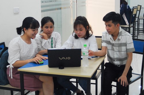 Ngọc Linh và Hải Yến (thứ hai và thứ tư, từ phải sang) giúp các bạn sinh viên khuyết tật học tập. Ảnh: Nam Phong