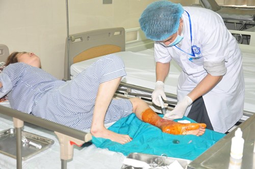 Bác sĩ chăm sóc bệnh nhân bị tiểu đường ngâm chân với lá cây không rõ nguồn gốc bị nhiễm trùng . Ảnh: Thúy Quỳnh