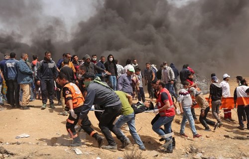 Chuyển người bị thương trong xung đột giữa người biểu tình Palestine và binh sĩ Israel phía Đông khu vực biên giới giữa Dải Gaza và Israel. Ảnh: TTXVN.