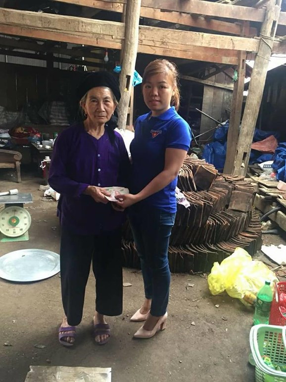 Thành viên Câu lạc bộ "Áo ấm vùng cao Pác Nặm" trao số tiền bán mận đến hộ dân bị thiệt hại trong trận mưa đá.