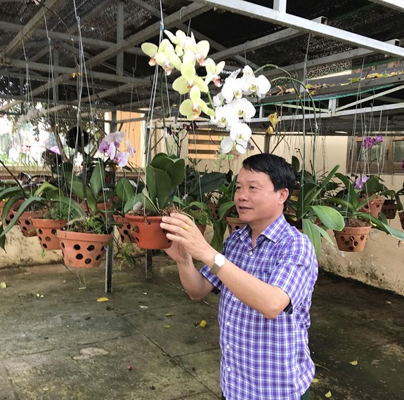 Đại tá Nguyễn Văn Lanh chăm sóc hoa phong lan sau giờ làm việc.