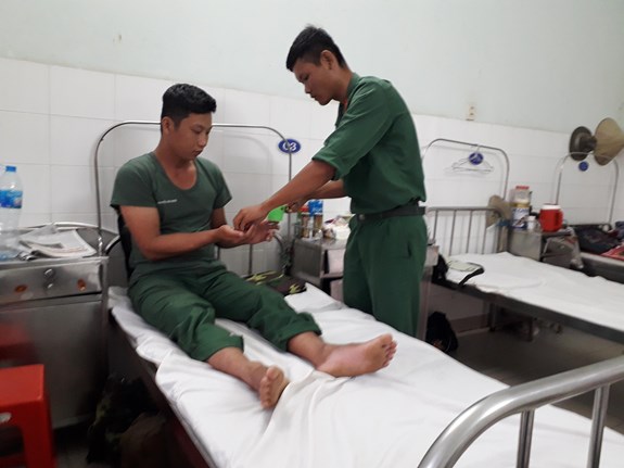 Trung sĩ Lê Minh Thi, y tá đơn vị đưa thuốc cho đồng đội.
