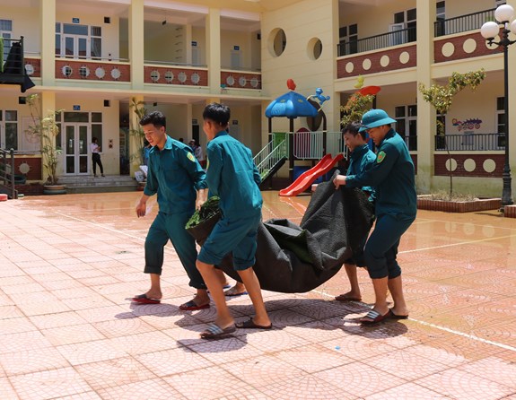 Lực lượng dân quân giúp phơi đồ tại trường mầm non Nam Phương Tiến.