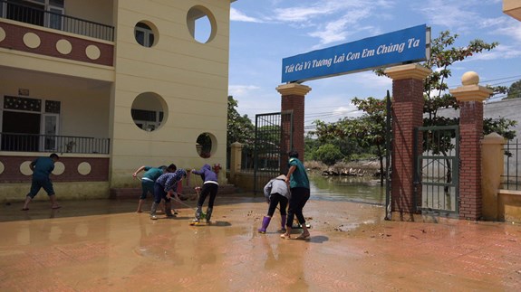 Tích cực làm sạch sân trường để đón học sinh về tựu trường vào đầu tháng 9 khi nước lũ rút hoàn toàn.