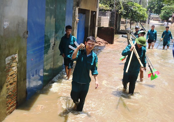 Các chiến sĩ dân quân lội nước đến giúp dân khắc phục hậu quả lũ lụt...