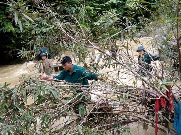 Lượng dân quân xã Tà Cạ, huyện Kỳ Sơn, tỉnh Nghệ An phối hợp giúp dân khắc phục hậu quả lũ lụt. Ảnh: Tùng Trí