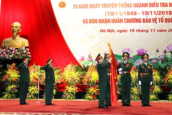 Thượng tướng Phan Văn Giang gắn Huân chương Bảo vệ Tổ quốc hạng Ba lên Quân kỳ Quyết thắng của Cục Điều tra hình sự.