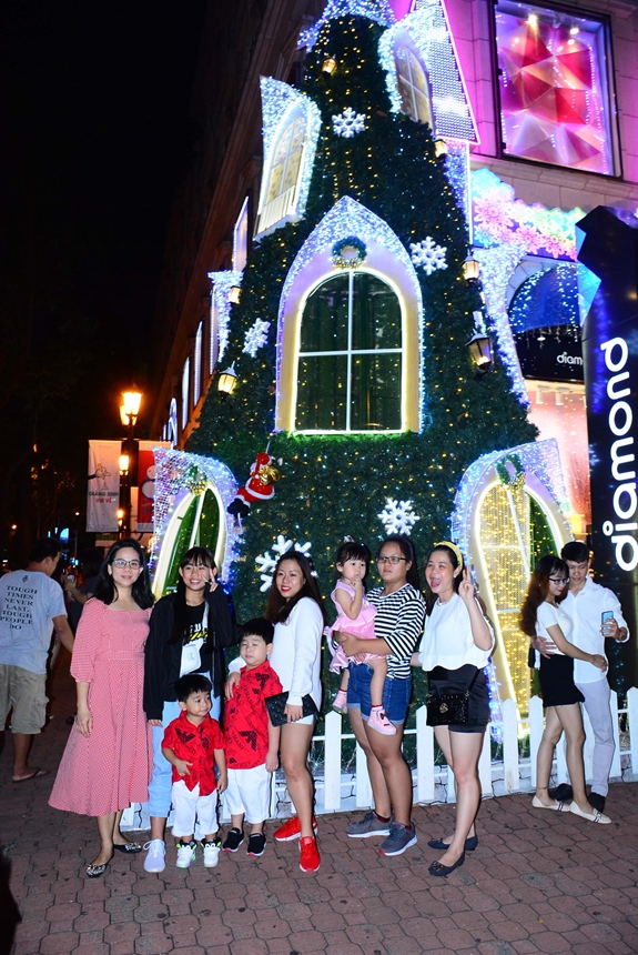 Chụp ảnh với cây thông Noel là bối cảnh không thể bỏ qua của các bạn trẻ.