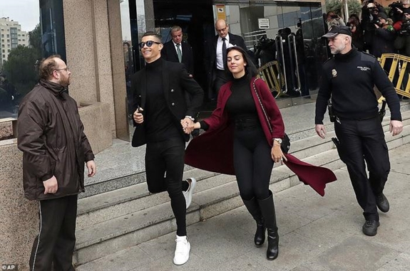 Ronaldo cùng bạn gái Georgina Rodríguez tươi cười rời khỏi tòa án Madrid. Ảnh: Getty Images.
