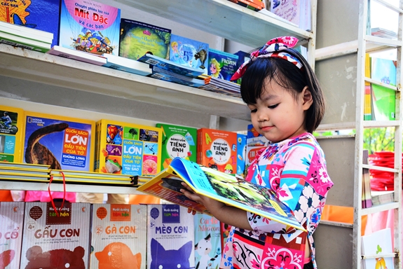 Một em thiếu nhi say sưa đọc sách.