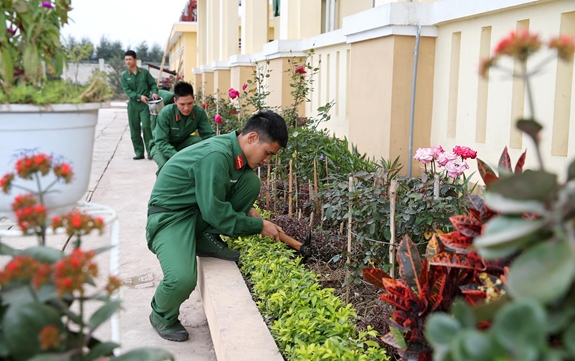 Chiến sĩ trẻ chăm sóc, cắt tỉa vườn hoa, cây cảnh trong khuôn viên đơn vị để tạo môi trường xanh, sạch, đẹp nhân dịp đón xuân Kỷ Hợi.