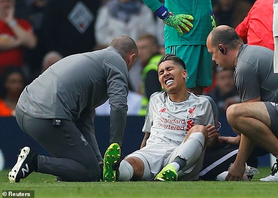 Firmino dính chấn thương sau tình huống lật cổ chân. Ảnh: Reuters