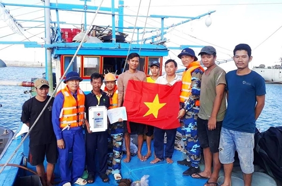 Cán bộ, nhân viên Trung tâm Hậu cần-Kỹ thuật thị trấn Trường Sa trao tặng ngư dân cờ Tổ quốc và tủ thuốc y tế.