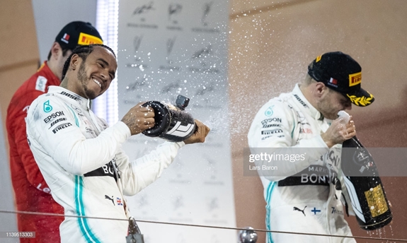 Lewis Hamilton (trái) bật sâm-panh ăn mừng cùng người đồng đội Valteri Bottas. Ảnh: Getty
