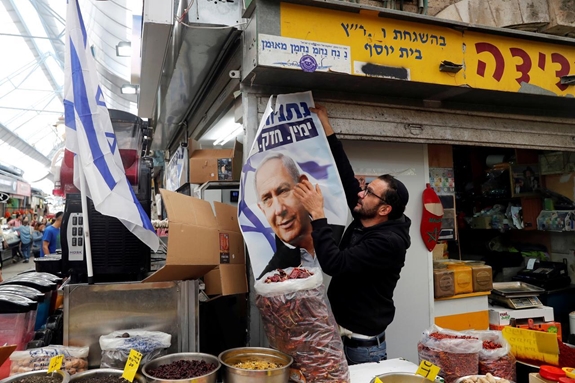 Một cử tri Israel cầm tấm áp-phích vận động tranh cử có hình ảnh Thủ tướng Benjamin Netanyahu. Ảnh: Reuters