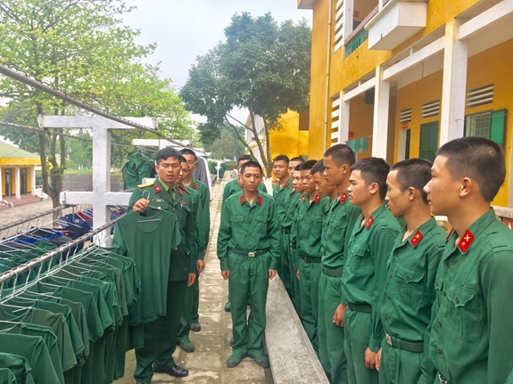Chiến sĩ mới Trung đoàn 141 theo dõi cán bộ hướng dẫn sắp đặt nội vụ.