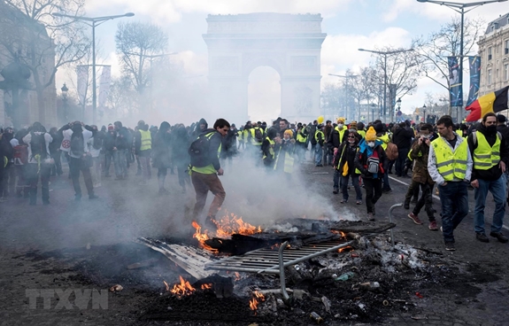 Người biểu tình "Áo vàng" đốt các rào chắn trên đại lộ Champs-Elysees tại thủ đô Paris, Pháp, ngày 16-3-2019.