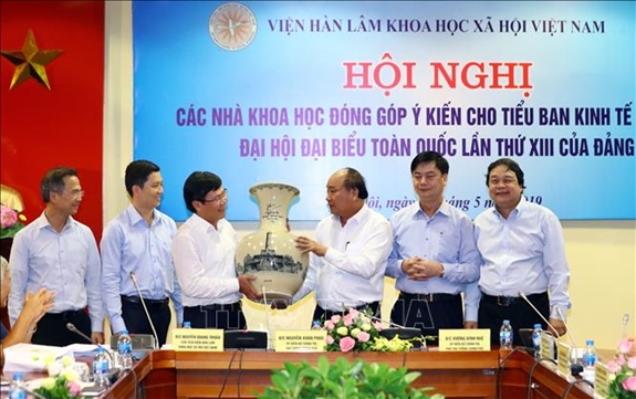 Thủ tướng Nguyễn Xuân Phúc trao quà lưu niệm tặng Viện hàn lâm Khoa học Xã hội Việt Nam. Ảnh: TTXVN.