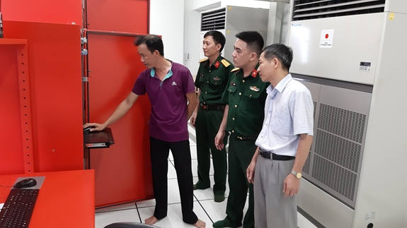 Quan trắc viên trạm ra đa giới thiệu với phóng viên Báo Quân đội nhân dân trang thiết bị quan trắc ra-đa được sử dụng tại trạm khí tượng Vinh.