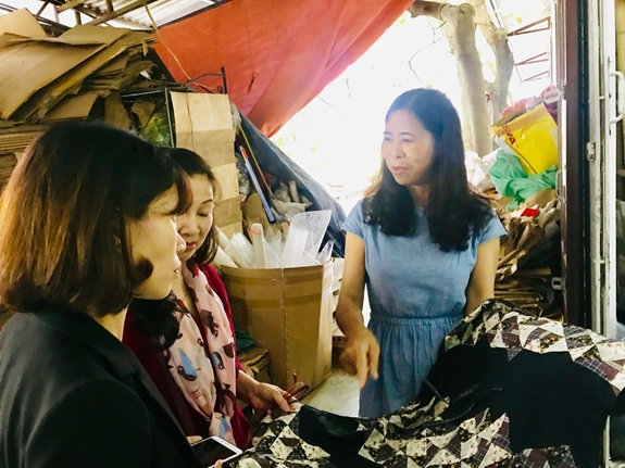 Chị Vũ Thị Hồng Yến (ngoài cùng, bên phải) giới thiệu tới khách tham quan sản phẩm thêu truyền thống.
