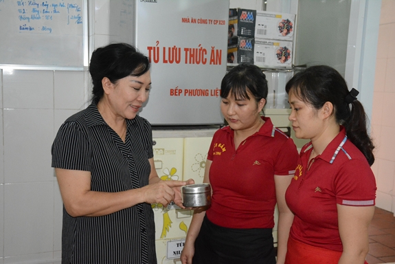 Chị Hải (bên trái) hướng dẫn nhân viên cách quản lý thức ăn mẫu tại tủ lưu nghiệm.