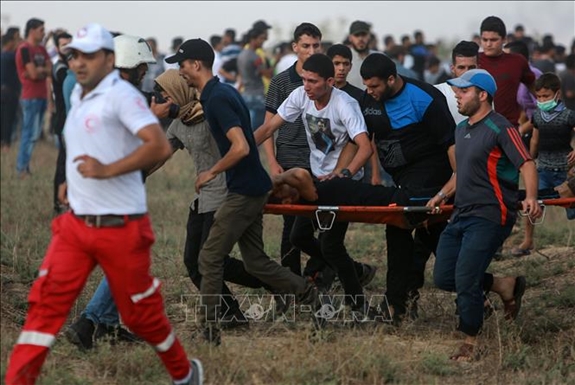 Chuyển người biểu tình Palestine bị thương trong cuộc xung đột với quân đội Israel ở khu vực biên giới Dải Gaza - Israel ngày 20-7. Ảnh: THX/TTXVN