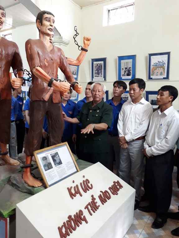 Cựu chiến binh Lâm Văn Bảng giới thiệu với du khách về những hiện vật tại bảo tàng.