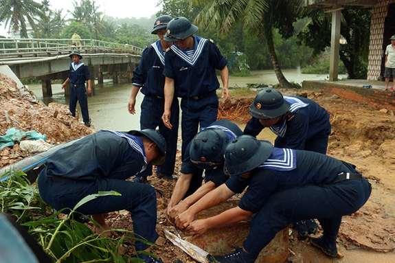 Cán bộ, chiến sĩ thu gom, vận chuyển đất đá trên 300m đường bị sạt lở.