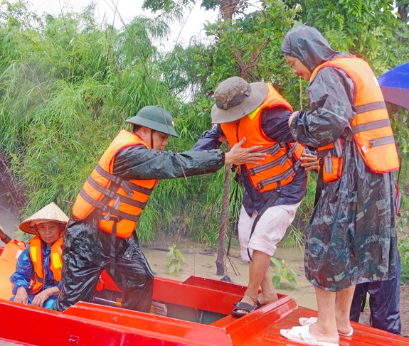 Cán bộ, chiến sĩ Đoàn Kinh tế-Quốc phòng 737, Quân khu 5 đưa người dân ra khỏi vùng lũ.