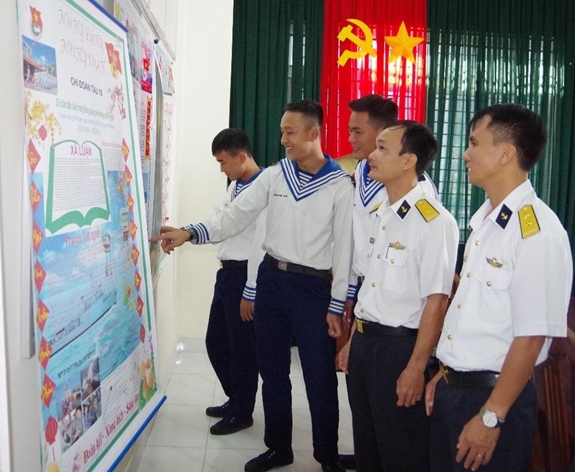 Cán bộ, chiến sĩ Tàu 18 xem báo tường trên tàu.
