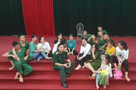 Anh Huy (quân phục) và chị Nguyệt (áo trắng, bên trái anh Huy) trò chuyện cùng các diễn viên trong đoàn.