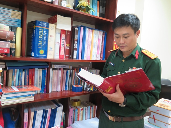 Trung tá Lê Huy Tuynh tìm ý tưởng khoa học từ tài liệu.