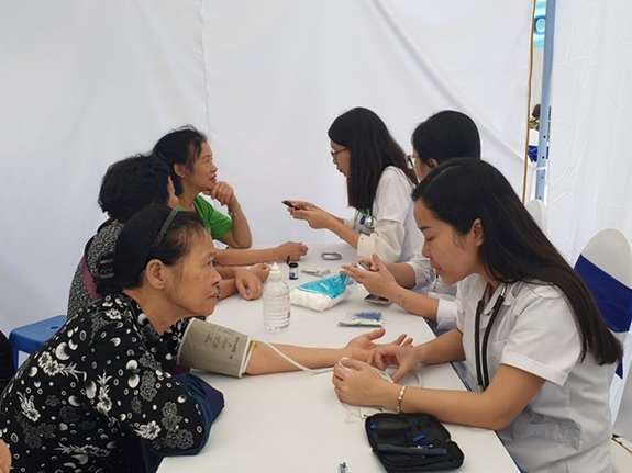 Người dân đến khám bệnh được đo huyết áp.