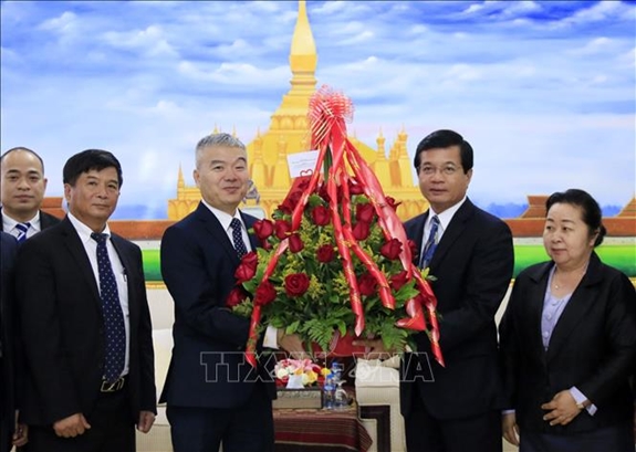 Đại diện Nguyễn Thanh Tùng chúc mừng Phó Trưởng Ban Đối ngoại Trung ương Lào Somphone Sichaleun. Ảnh: TTXVN