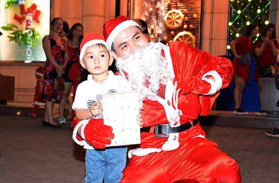 Ông già Noel chụp ảnh với em nhỏ.