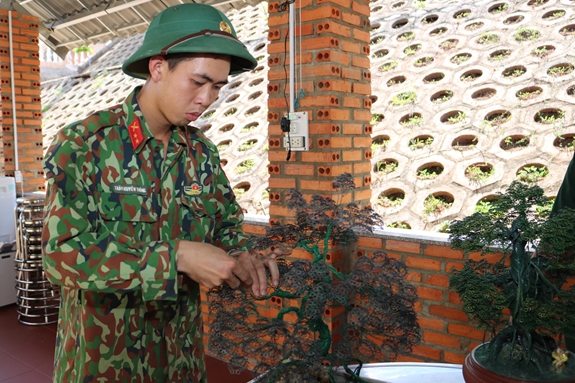 Binh nhất Trần Nguyên Thông với cây thông làm từ dây thép đã hoàn thành.