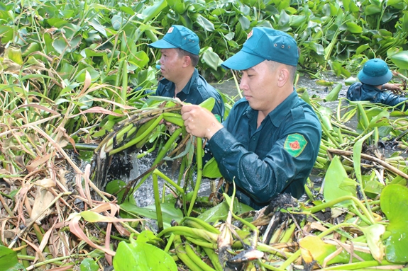 Dân quân tỉnh Long An hỗ trợ khơi thông dòng chảy dẫn nước chống hạn cứu lúa trên địa bàn huyện Tân Trụ. Ảnh: HOÀI DUY