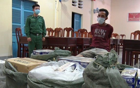 Lực lượng chức năng làm việc với đối tượng Dương Hỏi (ngồi) và số lượng tang vật thu giữ.