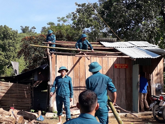 Lực lượng dân quân giúp nhân dân sửa chữa nhà ở.