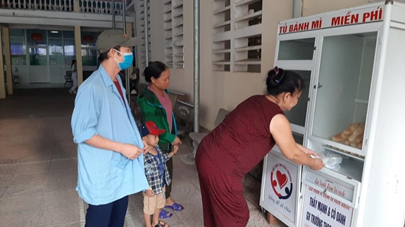 Bệnh nhân nhận bánh mì từ tủ miễn phí.