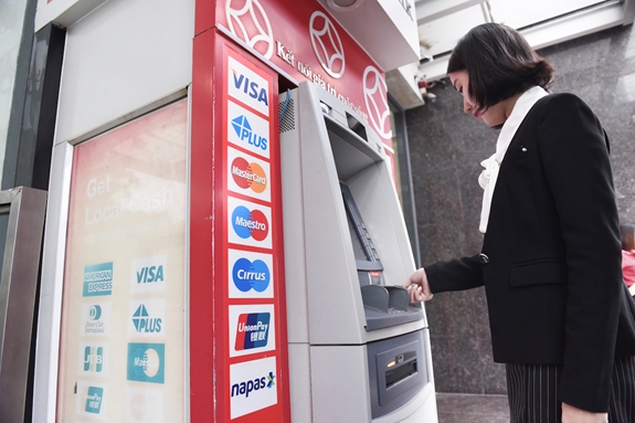 Khách hàng sử dụng thẻ thanh toán quốc tế tại máy ATM của Ngân hàng TMCP Đông Nam Á. Ảnh: VIỆT ANH