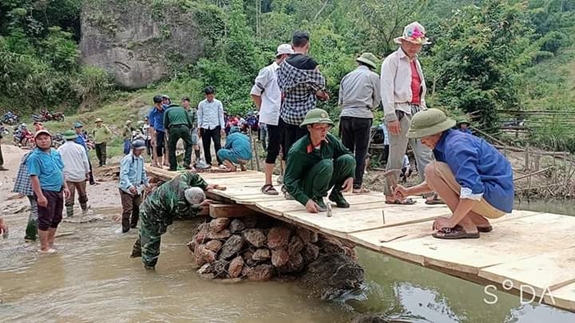 Cán bộ, nhân viên Đoàn Kinh tế-Quốc phòng 4 và bà con xã Tri Lễ bắc cầu qua suối Nậm Tột.