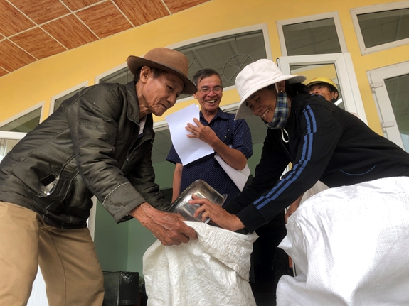 Ông Hoàng Văn Thạnh và nhiều hộ dân trong diện ưu tiên được nhận 15kg gạo tại Nhà văn hóa xã Quảng Vinh, huyện Quảng Điền.