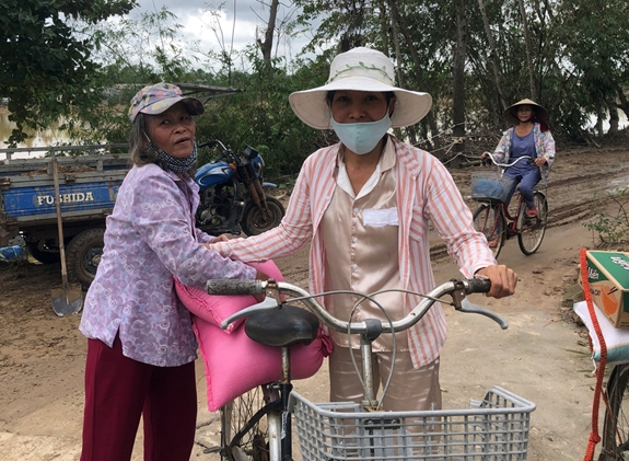 Giúp nhau chuyển lương thực được hỗ trợ về nhà.
