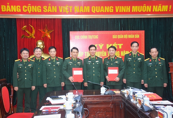 Thiếu tướng Nguyễn Văn Cường và các đại biểu chúc mừng thỏa thuận hợp tác truyền thông năm 2021 giữa Cục Chính trị và Báo QĐND.