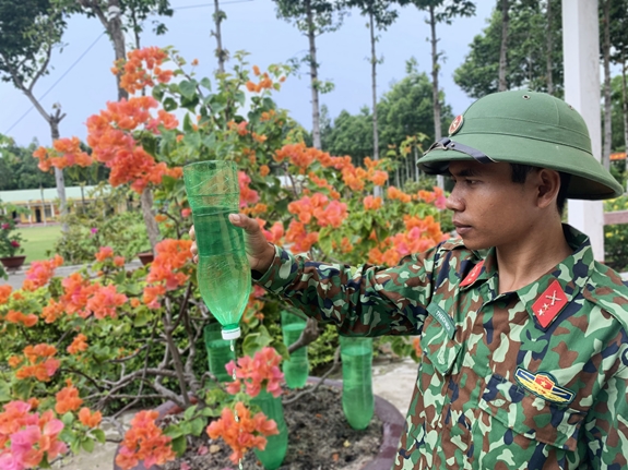 Binh nhất Thạch Mích thực hiện mô hình tưới nhỏ giọt bằng chai nhựa.